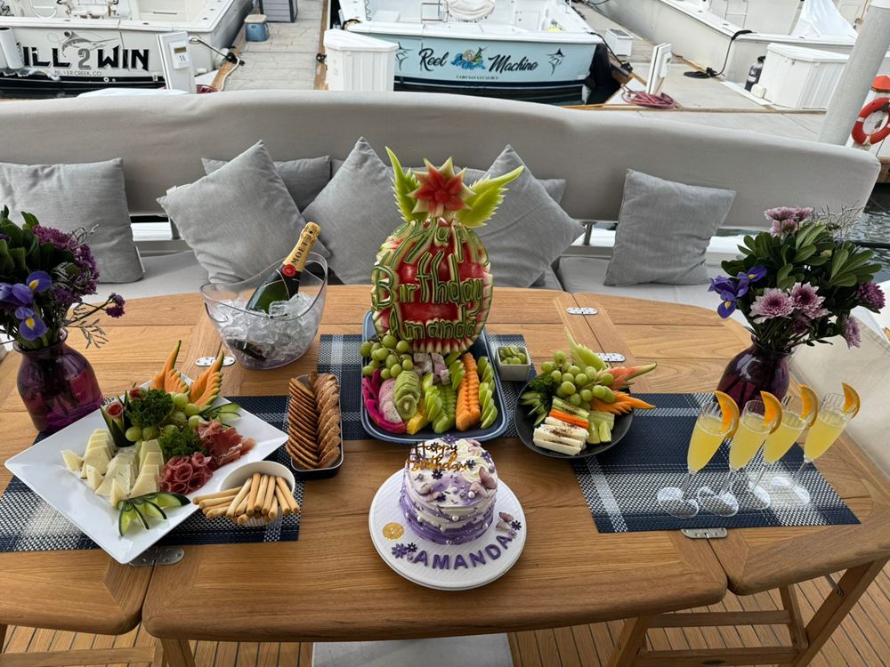 Mesa con fruta, botanas y flores servida en la cubierta de un yate